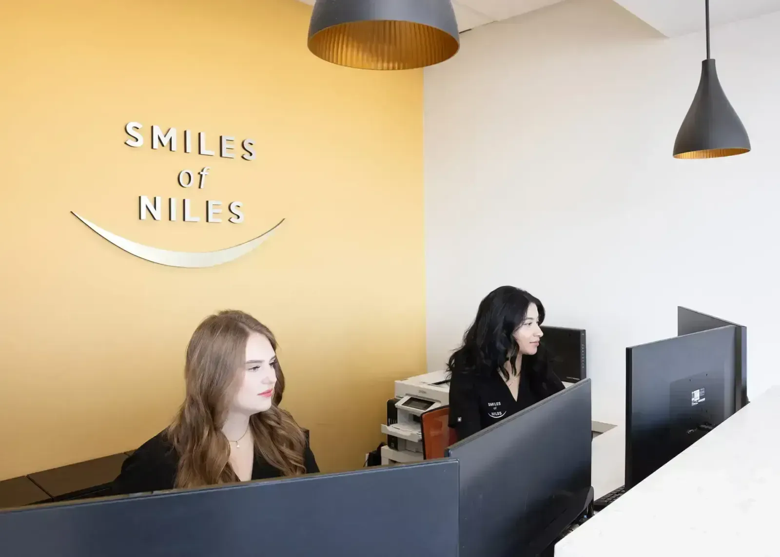 Front desk team at Smiles of Niles reviewing dental insurance and financing options with a patient in Niles, IL